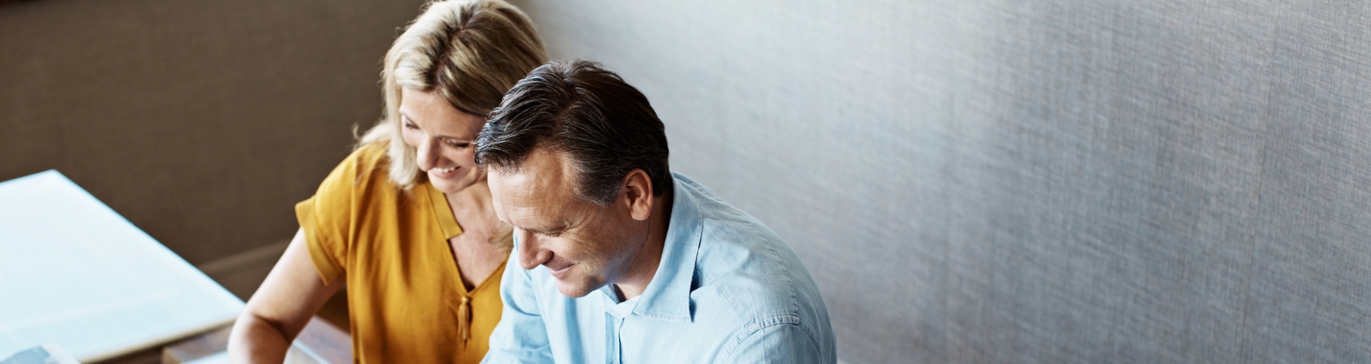 Shot of a mature couple paying their bills online from home